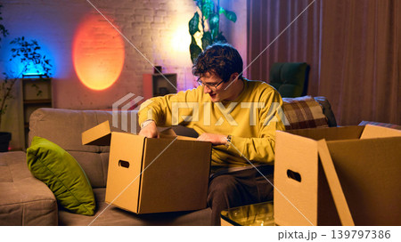 Man checking items inside delivery box at home ecommerce order fulfillment process 139797386