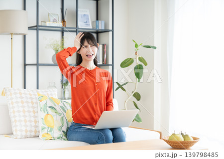 リビングでパソコンを使うミドルの女性 リビングでパソコンを使うミドルの女性 139798485