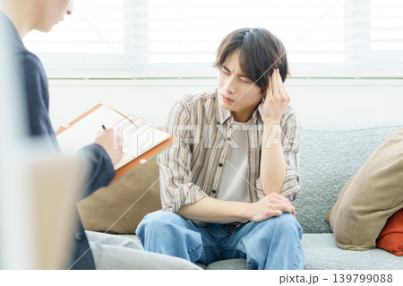 ソファに座ってカウンセリングを受ける若い日本人男性 139799088