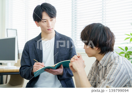 カウンセリング 話を聞きながらメモをとる若い日本人医師 カウンセリング 話を聞きながらメモをとる若い日本人医師 139799094