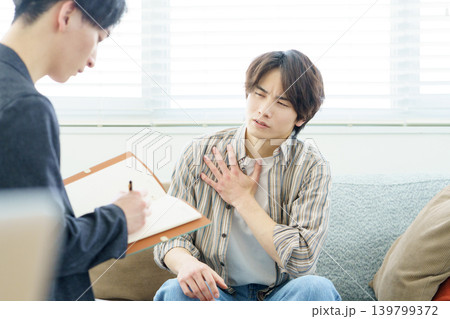 ソファに座ってカウンセリングを受ける若い日本人男性 ソファに座ってカウンセリングを受ける若い日本人男性 139799372
