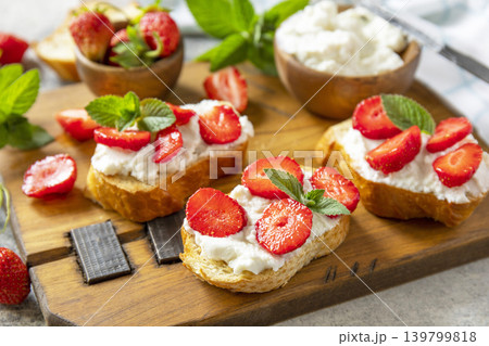 Bruschetta with ricotta and strawberry on a stone tabletop. Berries toast summer breakfast, healthy food. Bruschetta with ricotta and strawberry on a stone tabletop. Berries toast summer breakfast, healthy food. 139799818