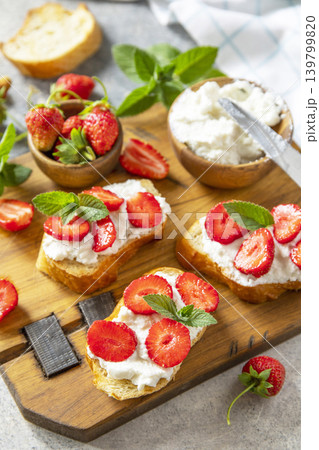 Bruschetta with ricotta and strawberry on a stone tabletop. Berries toast summer breakfast, healthy food. Bruschetta with ricotta and strawberry on a stone tabletop. Berries toast summer breakfast, healthy food. 139799820