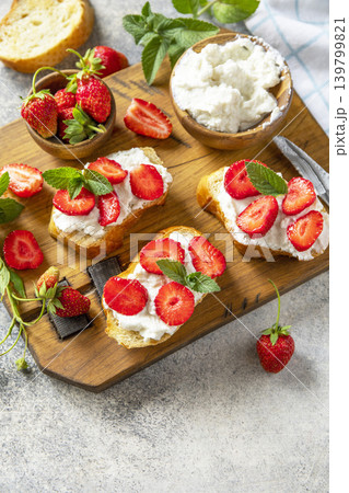 Bruschetta with ricotta and strawberry on a stone tabletop. Berries toast summer breakfast, healthy food. Copy space. 139799821
