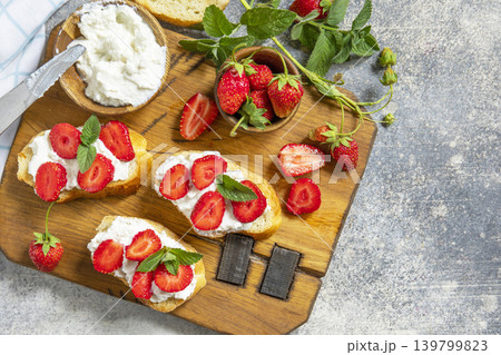 Bruschetta with ricotta and strawberry on a stone tabletop. Berries toast summer breakfast, healthy food. View from above. Copy space. Bruschetta with ricotta and strawberry on a stone tabletop. Berries toast summer breakfast, healthy food. View from above. Copy space. 139799823