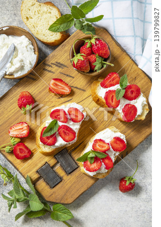 Bruschetta with ricotta and strawberry on a stone tabletop. Berries toast summer breakfast, healthy food. View from above. 139799827