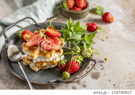 Belgian waffles with ricotta cheese and fresh strawberries for breakfast on a stone background. Sweet breakfast gluten free. Summer homemade recipe. Copy space. 139799927