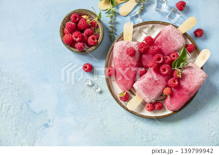 Healthy summer food concept, homemade raspberry ice cream. Vegan raspberry milk popsicles on a blue stone background. View from above. 139799942