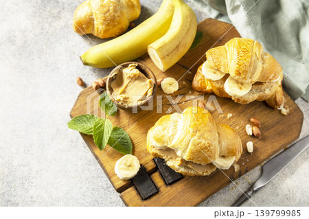 French pastry, freshly baked croissants with peanut butter and banana on a grey stone background. Healthy food dessert concept. Copy space. 139799985