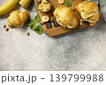 French pastry, freshly baked croissants with peanut butter and banana on a grey stone background. Healthy food dessert concept. View from above. Copy space. 139799988