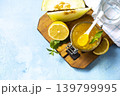 Sweet melon and citrus jam, homemade jelly preserves in small glass jar with fresh melon slices on a blue stone tabletop. Homemade preserve. Copy space. 139799995
