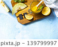 Sweet melon and citrus jam, homemade jelly preserves in small glass jar with fresh melon slices on a blue stone tabletop. Homemade preserve.  View from above. Copy space. 139799997
