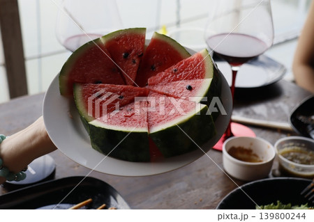 Fresh Watermelon Slices on Plate with Wine Glasses Fresh Watermelon Slices on Plate with Wine Glasses 139800244