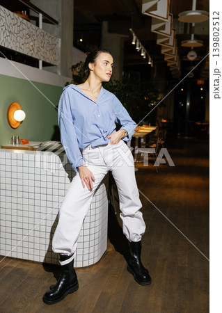 Woman posing in casual fashion outfit in restaurant Woman posing in casual fashion outfit in restaurant 139802512