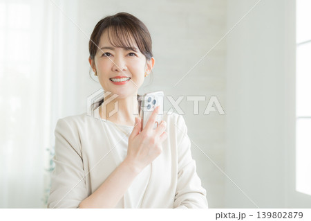 スマホを操作する笑顔の女性 スマホを操作する笑顔の女性 139802879