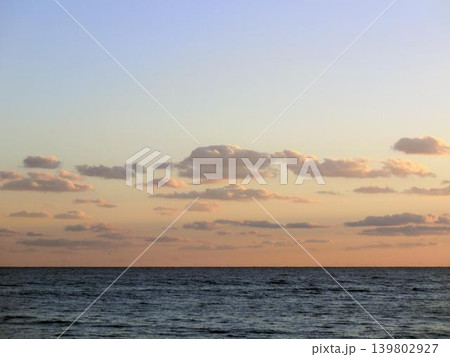 夕焼け空に浮かぶ雲と穏やかな海の風景 夕焼け空に浮かぶ雲と穏やかな海の風景 139802927