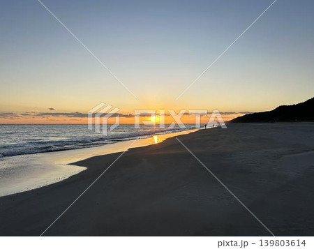 沈みゆく夕日と海岸のシルエット 沈みゆく夕日と海岸のシルエット 139803614