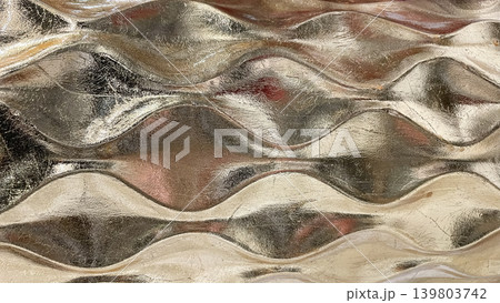 Luxury abstract golden metallic wave pattern with a reflective shiny surface in a macro view Luxury abstract golden metallic wave pattern with a reflective shiny surface in a macro view 139803742
