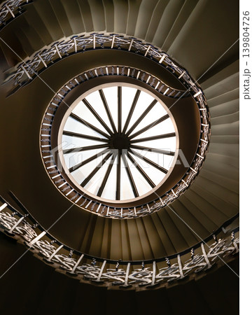 Looking up reveals a hypnotic vortex of timeless beauty. A wheel-like skylight casts a radiant glow over the inner rings, fading into deep shadows that accentuate the geometric steps. Sweeping upward Looking up reveals a hypnotic vortex of timeless beauty. A wheel-like skylight casts a radiant glow over the inner rings, fading into deep shadows that accentuate the geometric steps. Sweeping upward 139804726