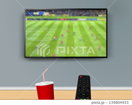 Watching online soccer match with remote control and cola drink cup 139804933