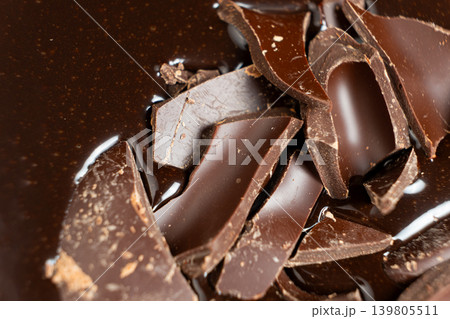 Dark chocolate chunks into liquid melted chocolate sauce background Dark chocolate chunks into liquid melted chocolate sauce background 139805511