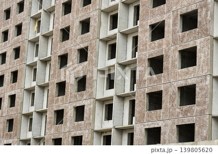 Mid range view raw concrete blocks and empty window voids, modular housing shell under inspection, developer survey Mid range view raw concrete blocks and empty window voids, modular housing shell under inspection, developer survey 139805620