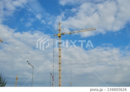 Low angle view of heavy lifting equipment and concrete building structure under development on a bright daytime 139805626