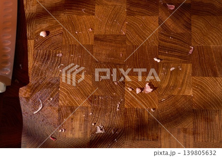 Top down view of a chef knife and meat scraps on a wooden cutting board Top down view of a chef knife and meat scraps on a wooden cutting board 139805632