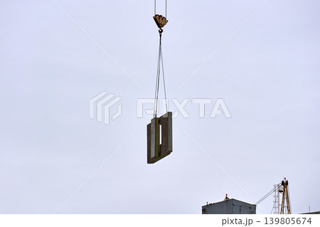Housing development: installing concrete wall segments with a crane 139805674