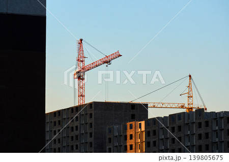 Two tower cranes building a modern concrete skyscraper Two tower cranes building a modern concrete skyscraper 139805675