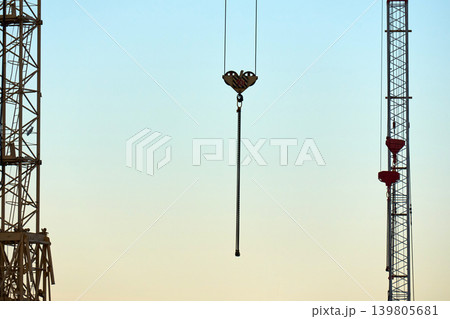 Crane hooks and steel cables against clear blue sky 139805681