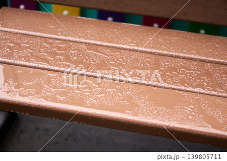 Rainy weather in the city: Drops of water on a park bench during seasonal transition, soft natural lighting 139805711