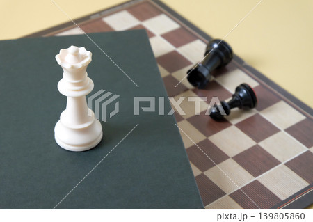 Chess pieces on old book over chess board game. Chess pieces on old book over chess board game. 139805860