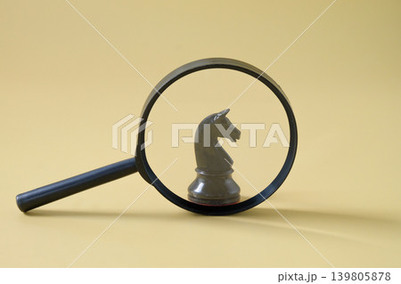 Chess pieces is viewed through a magnifying glass. 139805878