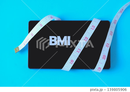 Tablet with measuring tape on background. Tablet with measuring tape on background. 139805906