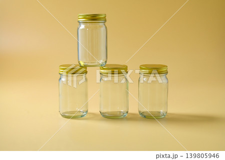 A glass storage jar with a gold metallic lid. A glass storage jar with a gold metallic lid. 139805946