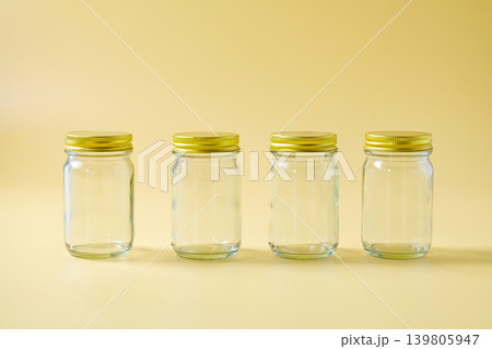 A glass storage jar with a gold metallic lid. A glass storage jar with a gold metallic lid. 139805947