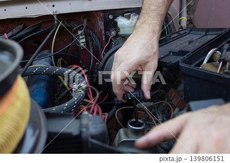 Man checking engine oil with dipstick during vehicle maintenance Man checking engine oil with dipstick during vehicle maintenance 139806151