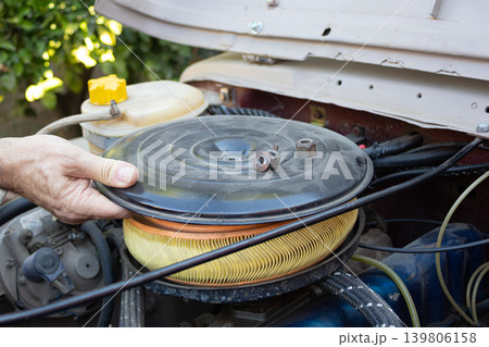 Mechanic replacing car air filter during vehicle maintenance Mechanic replacing car air filter during vehicle maintenance 139806158
