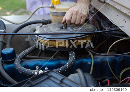Mechanic man working on jeep engine air filter Mechanic man working on jeep engine air filter 139806160