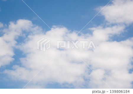 Bright blue sky featuring white fluffy cumulus and stratocumulus clouds, presenting a serene celestial backdrop 139806184