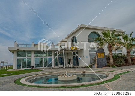 Modern architectural gem on the coast surrounded by palm trees and serene water features 139806283