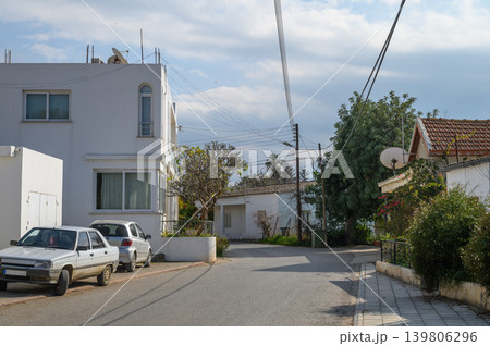Cozy street in a peaceful neighborhood with charming houses and clear skies Cozy street in a peaceful neighborhood with charming houses and clear skies 139806296