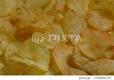 Golden and crispy potato chips piled high in a casual gathering, inviting everyone to enjoy their crunchiness at sunset Golden and crispy potato chips piled high in a casual gathering, inviting everyone to enjoy their crunchiness at sunset 139806329