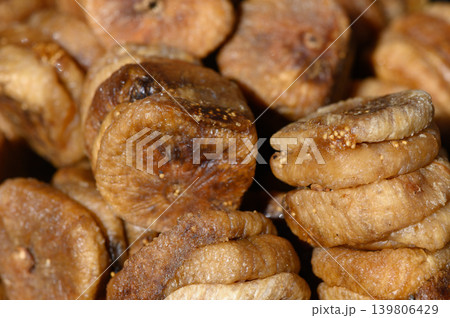 Dried figs piled together showcasing rich textures and natural sweetness in a lively market setting Dried figs piled together showcasing rich textures and natural sweetness in a lively market setting 139806429