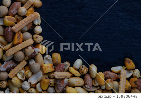 Colorful assortment of crunchy snacks arranged artistically on a dark surface creates an inviting atmosphere for casual gatherings 139806448