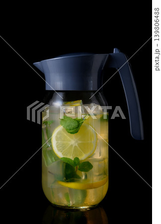 Glass Pitcher with Blue Lid Filled with Lemonade on Black Glass Pitcher with Blue Lid Filled with Lemonade on Black 139806488