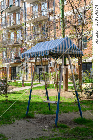 Swing set with blue-and-white striped canopy on playground 139806574