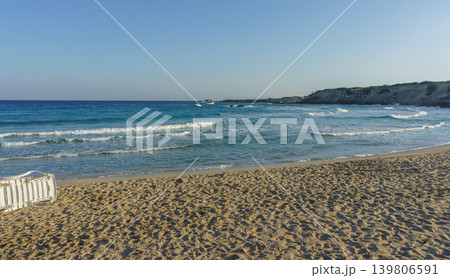 Serene beach view with gentle waves and a clear sky at sunset in a coastal paradise. Serene beach view with gentle waves and a clear sky at sunset in a coastal paradise. 139806591