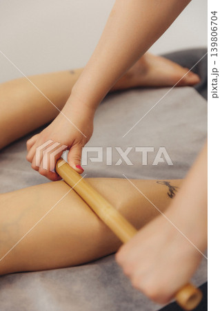 Soft hands use a wooden roller on a relaxed leg Soft hands use a wooden roller on a relaxed leg 139806704